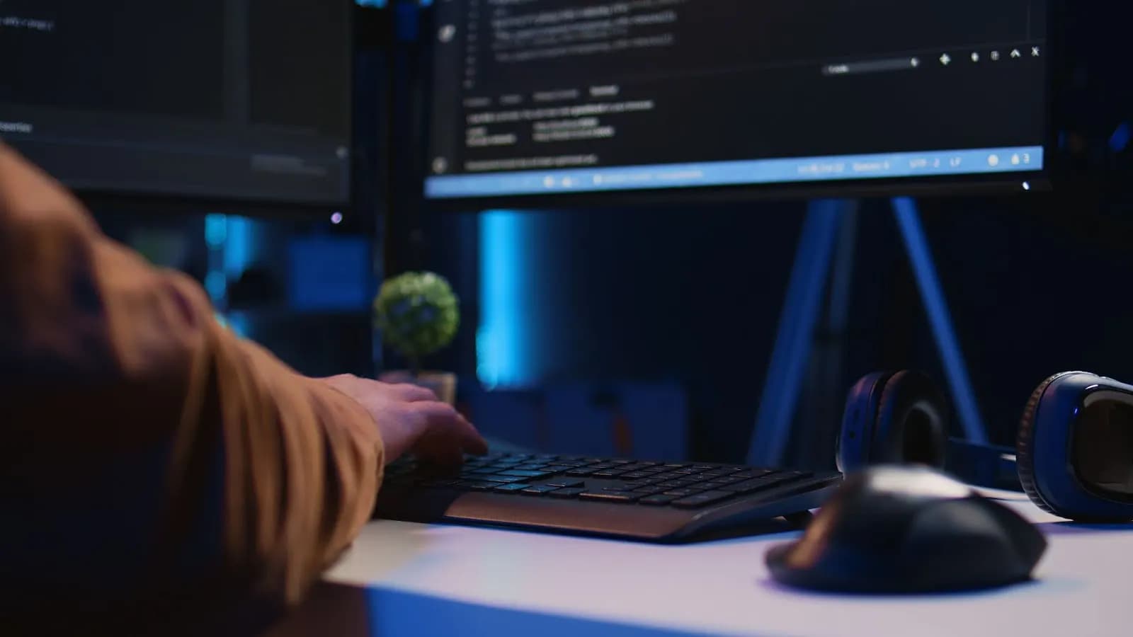 No-code app development on laptop with multiple monitors in office environment